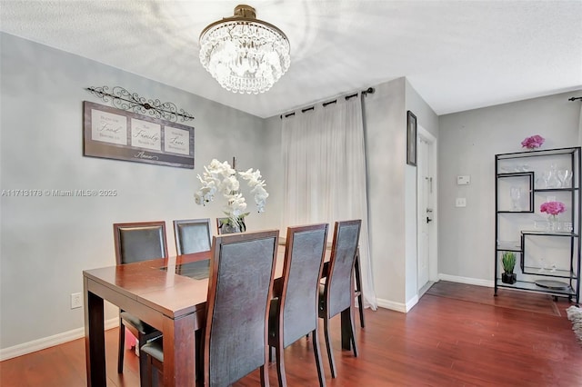 dining room with baseboards, an inviting chandelier, and wood finished floors