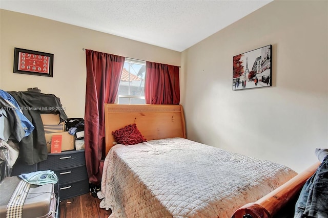 bedroom featuring wood finished floors and a textured ceiling