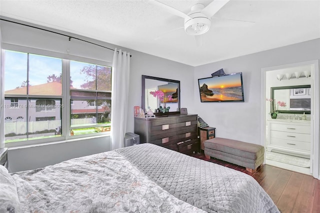 bedroom with a ceiling fan, ensuite bath, and wood finished floors