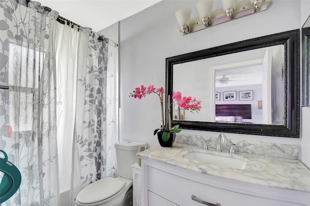 bathroom featuring vanity, toilet, a ceiling fan, and shower / bath combo with shower curtain