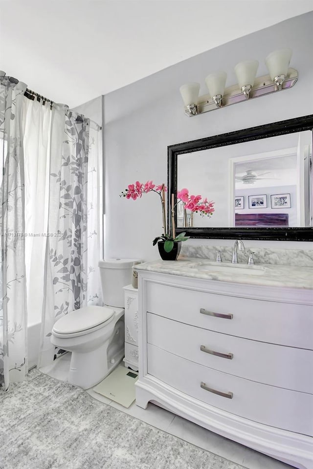 bathroom featuring tile patterned flooring, toilet, vanity, and shower / bath combination with curtain