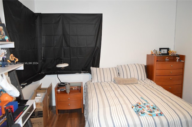 bedroom with dark hardwood / wood-style floors