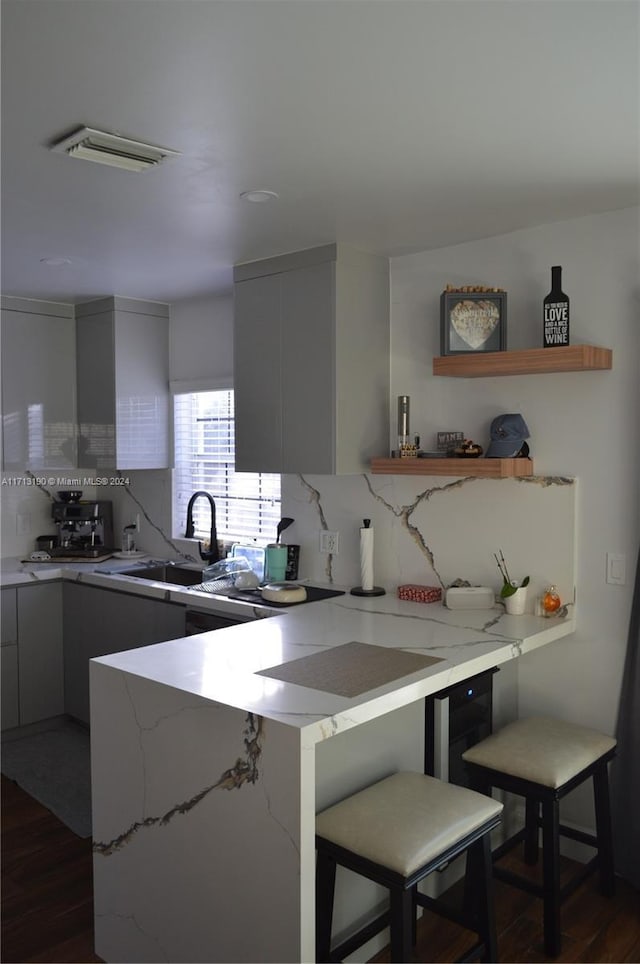 kitchen featuring a kitchen breakfast bar, dark wood-type flooring, and sink