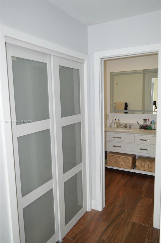 corridor with dark hardwood / wood-style floors and sink