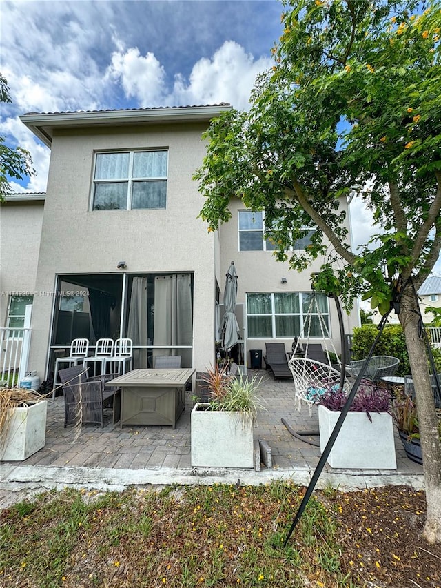 back of house with an outdoor living space and a patio area