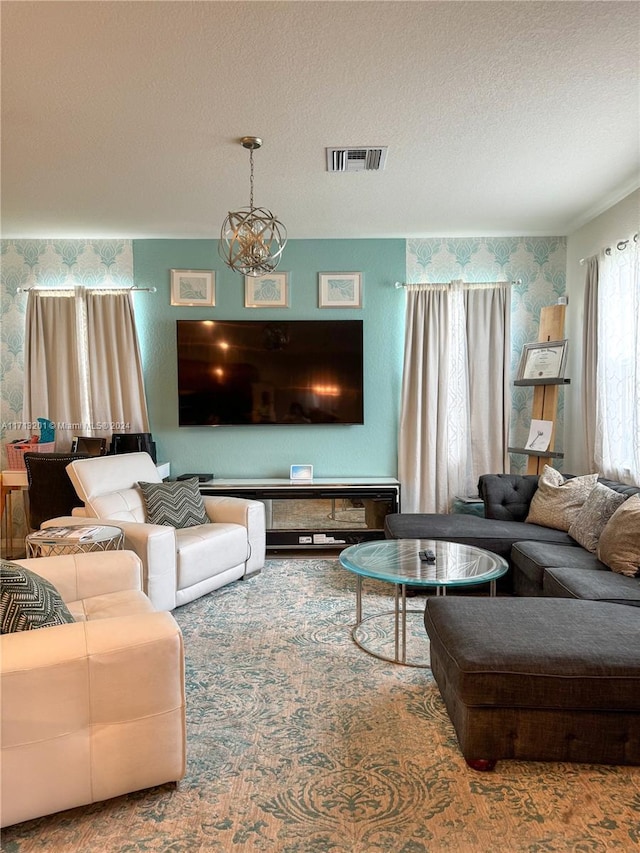 living room featuring a textured ceiling and an inviting chandelier