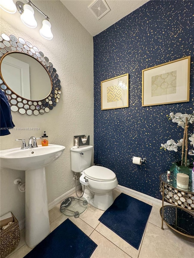 bathroom featuring tile patterned floors, toilet, and a textured ceiling