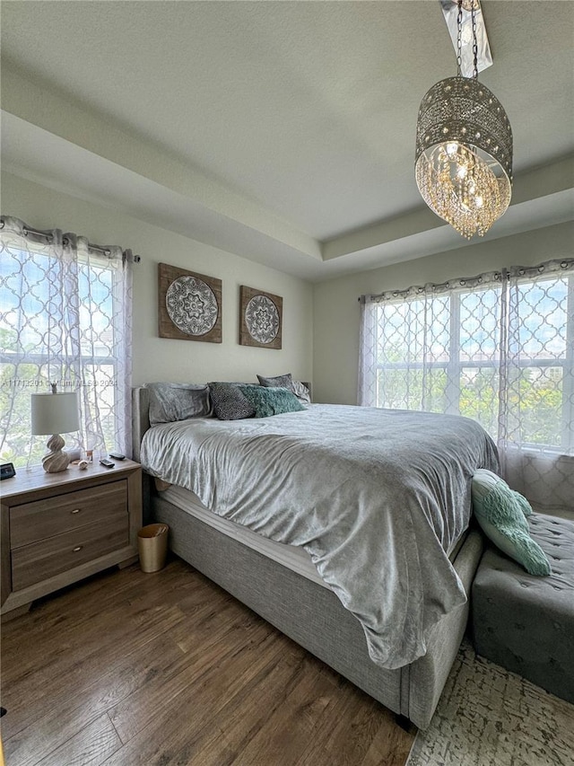 bedroom featuring dark wood-type flooring and a notable chandelier