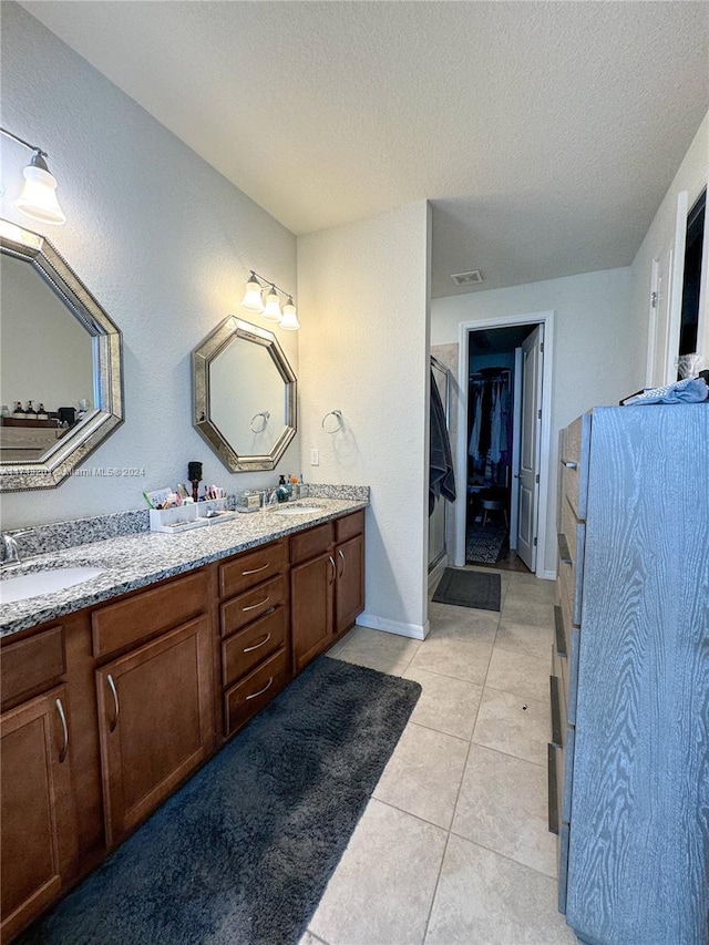 bathroom with tile patterned floors, vanity, and a textured ceiling