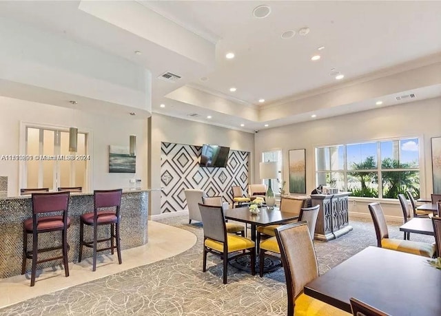 dining room with a tray ceiling and tile patterned flooring