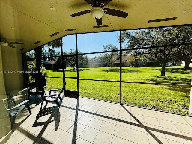 unfurnished sunroom featuring ceiling fan and vaulted ceiling