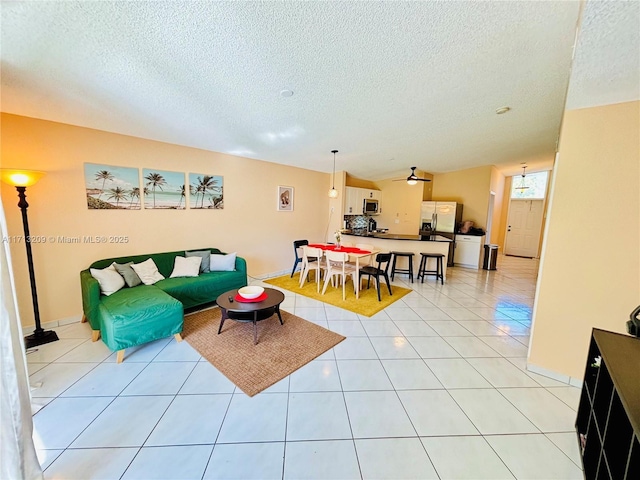 tiled living room featuring ceiling fan and a textured ceiling