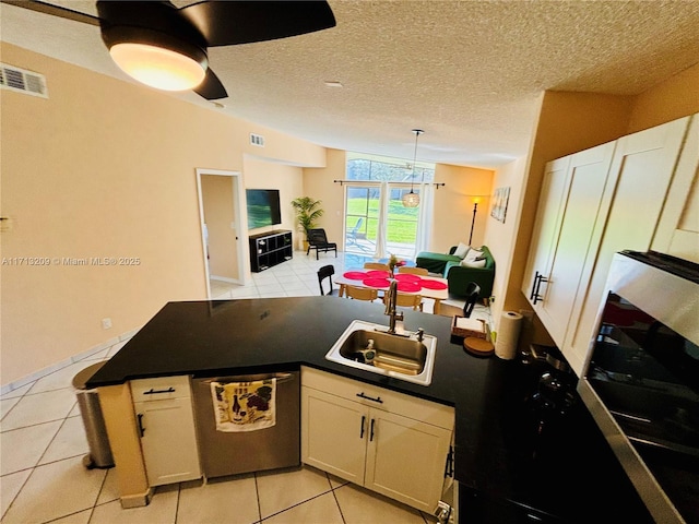 kitchen with light tile patterned floors, dishwasher, sink, and white cabinetry