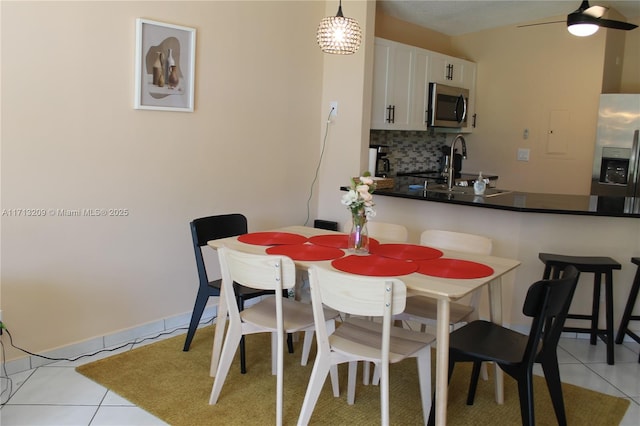 tiled dining space featuring ceiling fan and sink