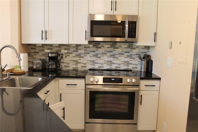 kitchen with tasteful backsplash, white cabinets, sink, and stainless steel appliances