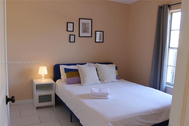 bedroom featuring light tile patterned floors and multiple windows