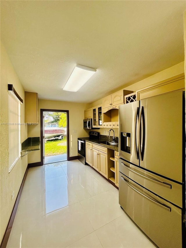 kitchen featuring light tile patterned floors, a textured ceiling, stainless steel appliances, and sink