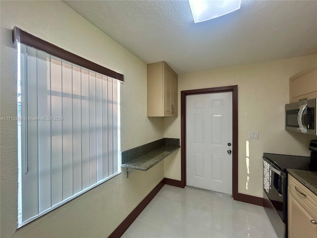 kitchen with appliances with stainless steel finishes, a textured ceiling, and light brown cabinetry