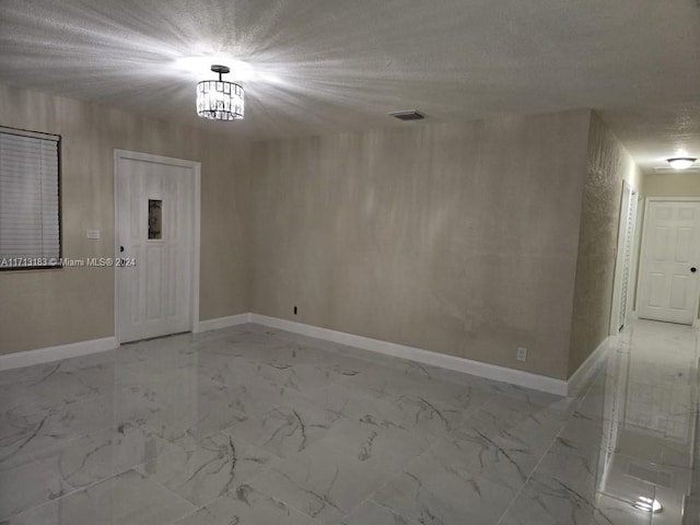 unfurnished room featuring a textured ceiling