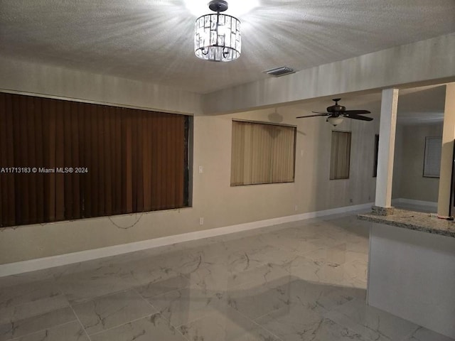 empty room featuring ceiling fan and a textured ceiling