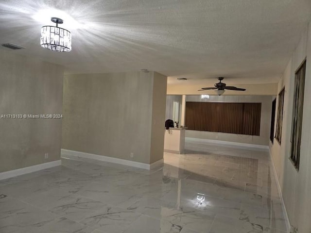 empty room featuring a textured ceiling and ceiling fan