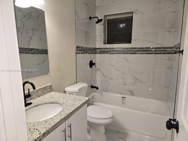 full bathroom with vanity, tiled shower / bath combo, and toilet