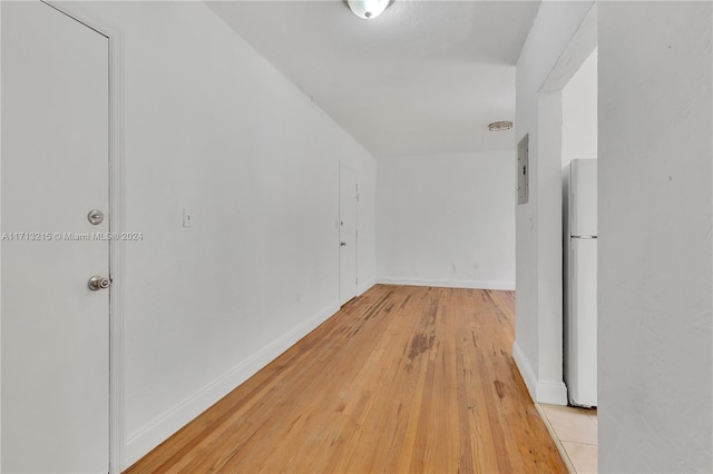 hallway with light hardwood / wood-style floors and electric panel