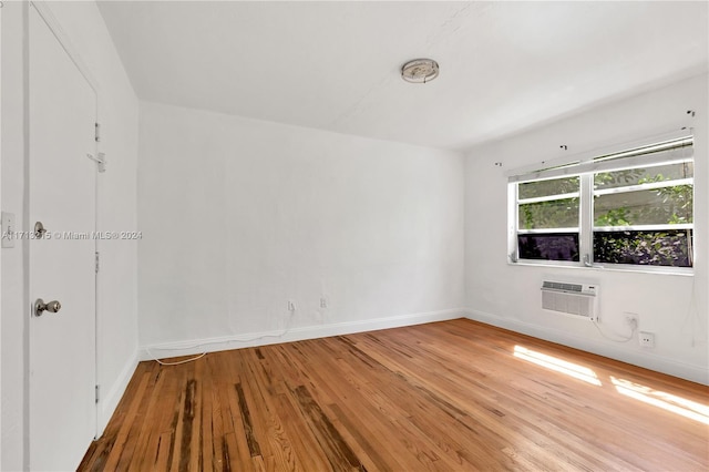 empty room with hardwood / wood-style floors and a wall unit AC