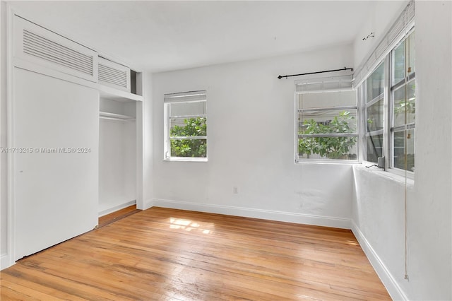 unfurnished bedroom with a closet and hardwood / wood-style flooring