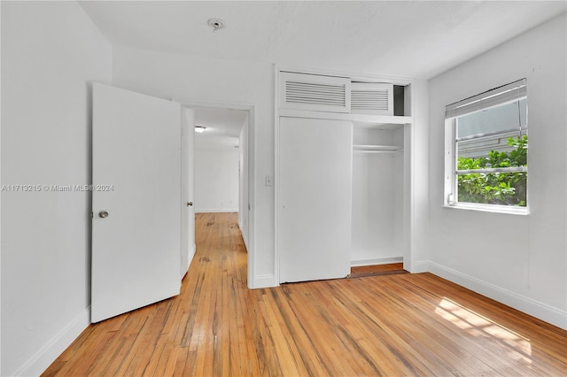 unfurnished bedroom with a closet and light wood-type flooring