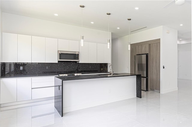 kitchen featuring sink, a kitchen island with sink, stainless steel appliances, white cabinets, and decorative light fixtures