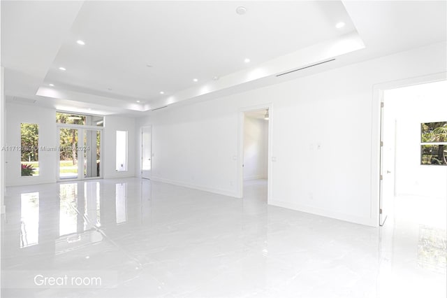 unfurnished room featuring french doors and a tray ceiling