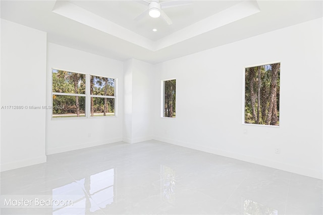 unfurnished room with a raised ceiling and ceiling fan