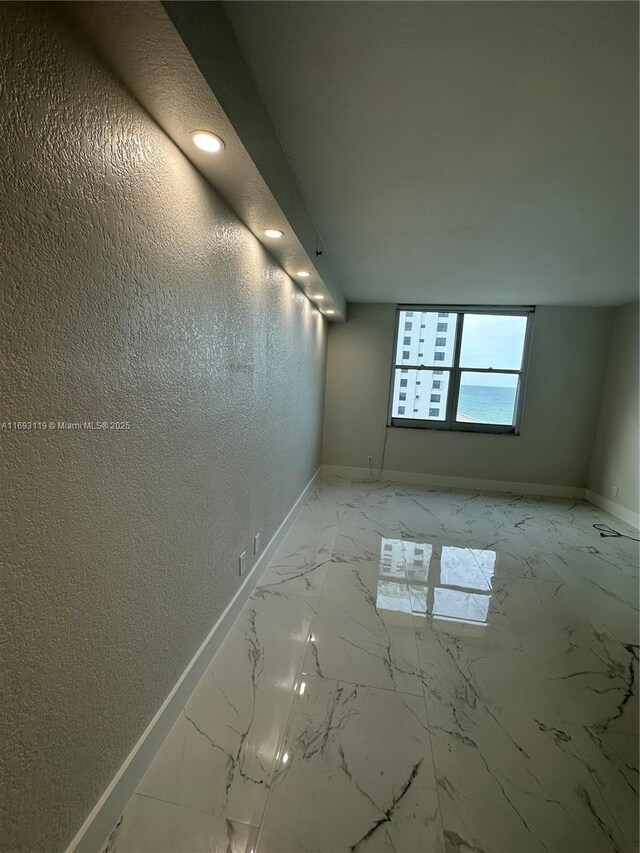 2501 S Ocean Dr Unit 1208, Hollywood, FL 33019 - unfurnished room with baseboards, a textured wall, light marble finish flooring, and recessed lighting