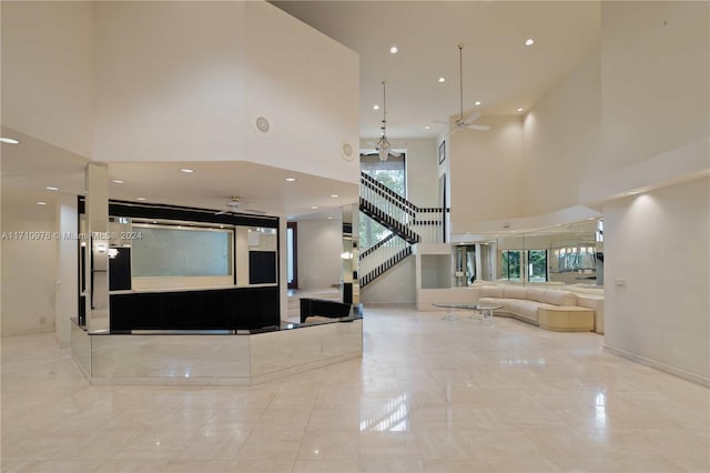 interior space featuring a towering ceiling and ceiling fan