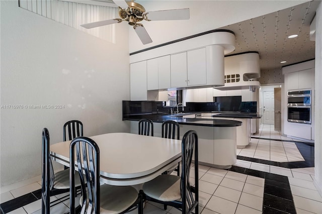 dining area with ceiling fan, sink, and light tile patterned floors