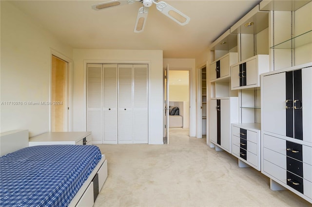 carpeted bedroom featuring ceiling fan and a closet