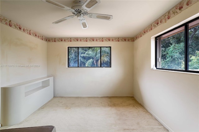 carpeted spare room featuring ceiling fan