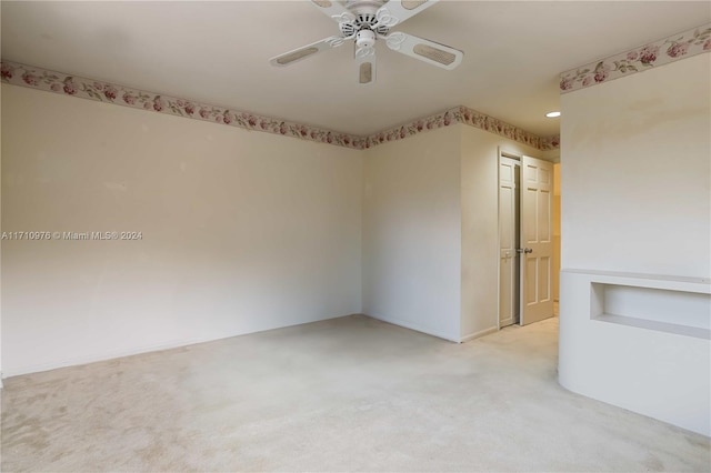 spare room featuring ceiling fan and light carpet