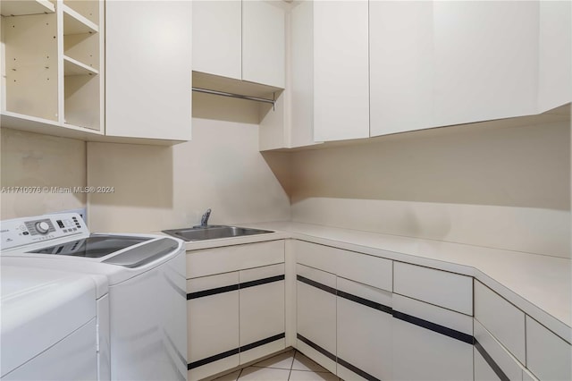 laundry area featuring cabinets, separate washer and dryer, sink, and light tile patterned floors