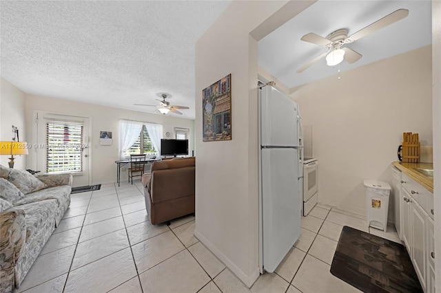 kitchen with ceiling fan, white cabinetry, white appliances, and a textured ceiling