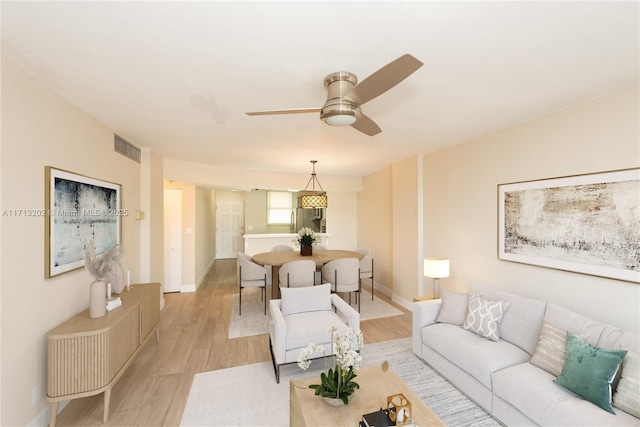 living room with light wood-type flooring and ceiling fan