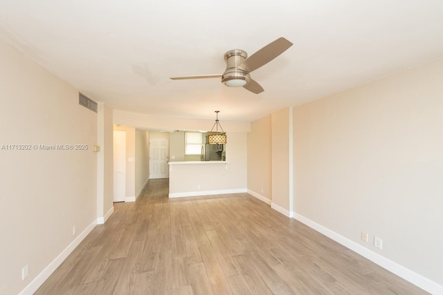 spare room with light wood-type flooring and ceiling fan