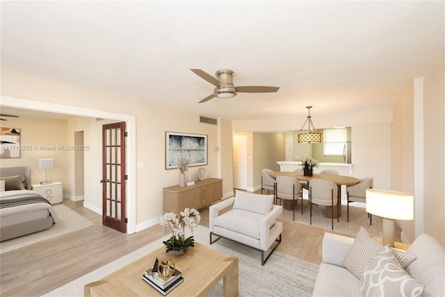 living room with ceiling fan and light hardwood / wood-style floors