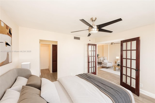 bedroom with french doors, light wood-type flooring, and ceiling fan