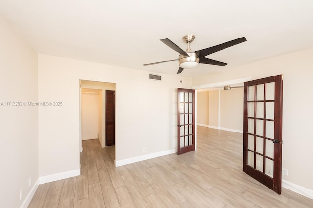 empty room with ceiling fan, french doors, and light hardwood / wood-style flooring