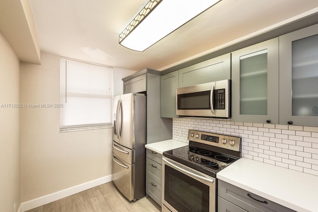 kitchen featuring decorative backsplash, light wood-type flooring, and appliances with stainless steel finishes