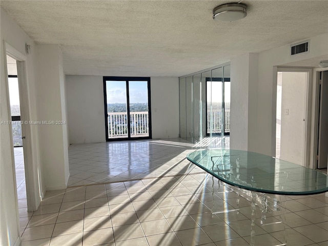 unfurnished room featuring light tile patterned flooring and a textured ceiling