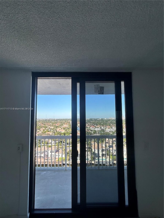 doorway to outside with a textured ceiling and a wealth of natural light