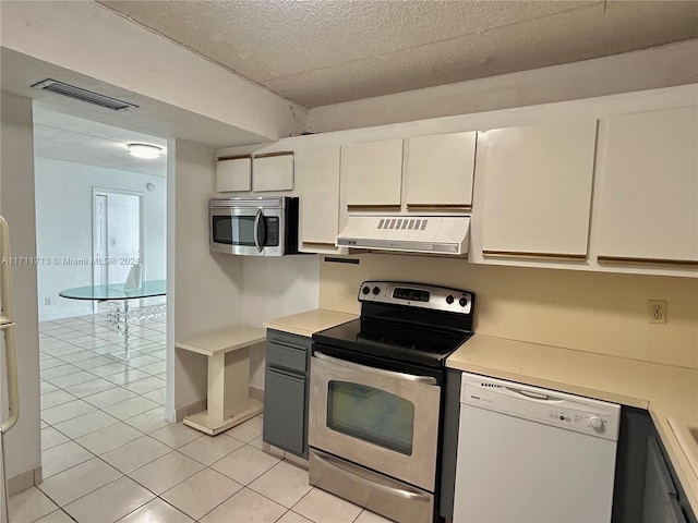 kitchen featuring exhaust hood, white cabinets, stainless steel appliances, and light tile patterned floors